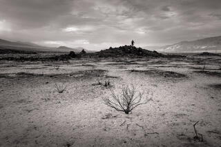 Native American Mannequin on small hill in a burned field, INyo County, California
