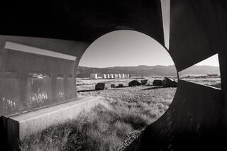 Pump housings seen through round, wildlife viewing shelters, Owens Lake